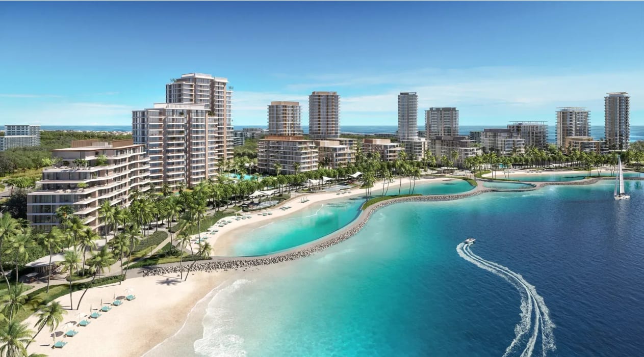 Aerial view of a Dubai waterfront community — luxury off-plan and ready residences beside a turquoise lagoon and beach