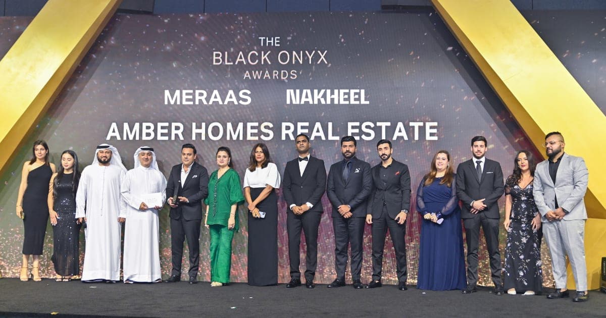 The Amber Homes Real Estate team on stage at The Black Onyx Awards, beneath Meraas and Nakheel branding
